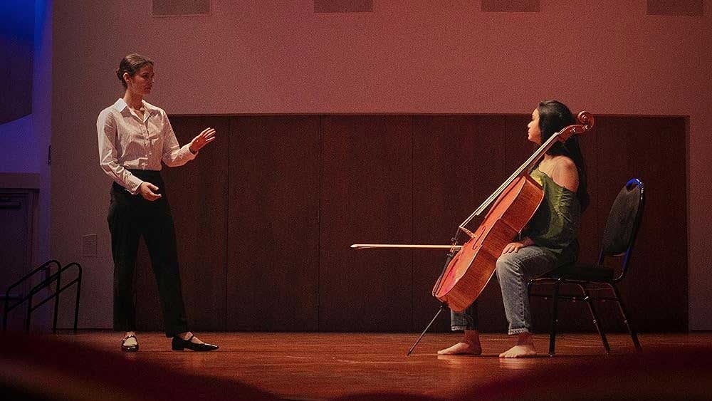 woman on stage with cello and composer