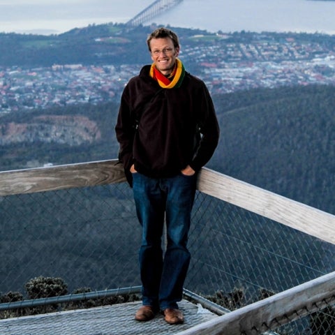 Chris Jenkins smiles on a deck overlooking a waterfront city