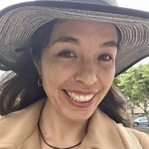 Melody Jue wears a large hat and a tan jacket